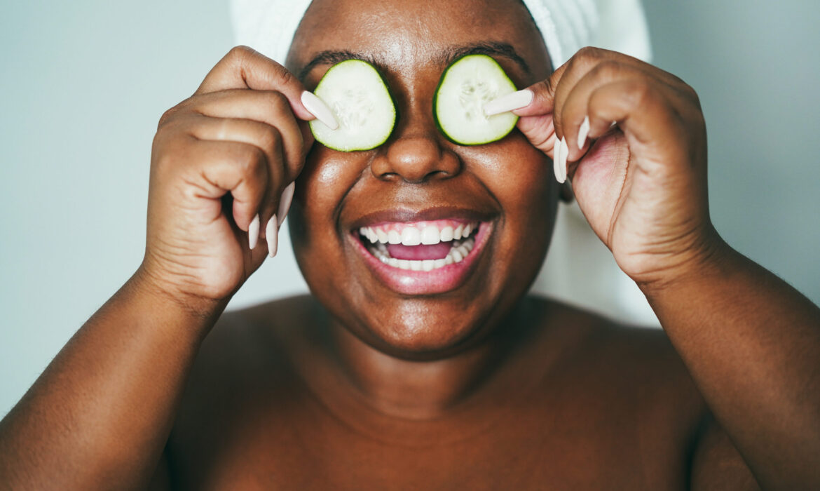 Young african girl having fun holding cucumber skin care therapy – Main focus on nose
